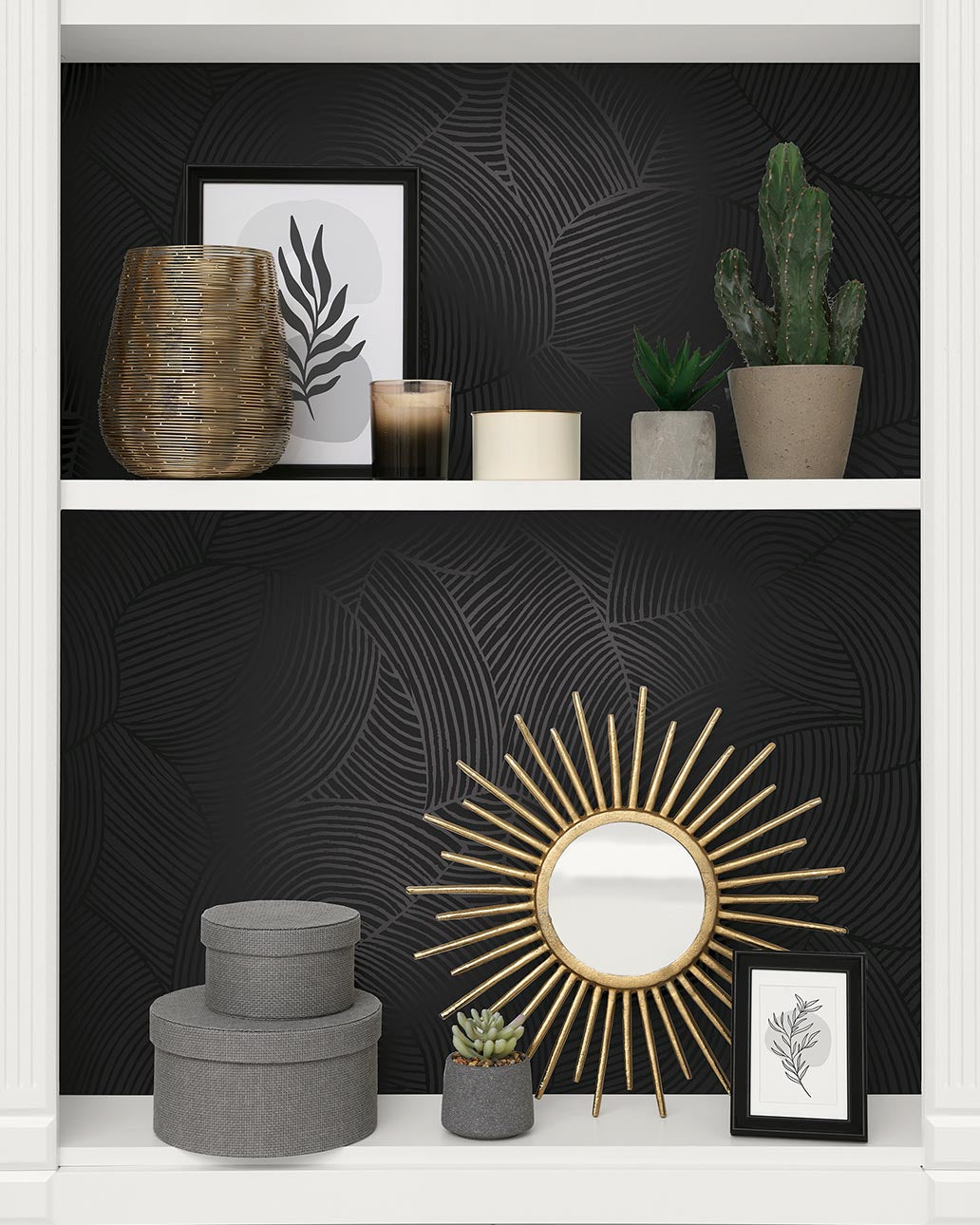 Decorative shelf with a gold mirror, plants, and framed artwork against a black textured wall.