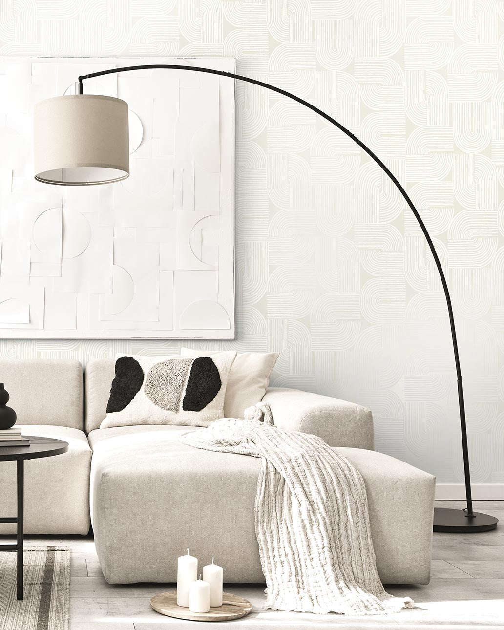 Modern living room with a beige sectional sofa, floor lamp, and decorative pillows.