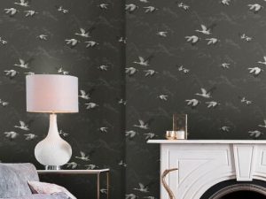 Animalia Dark Steel Wallpaper is a gorgeous pattern of grey and white cranes, amongst the outline of clouds with a matt dark steel background.