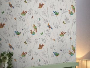 Aviary Natural Wallpaper is charming and conversational featuring birds and butterflies parading across branches and dappled leaves, timeless and fresh.