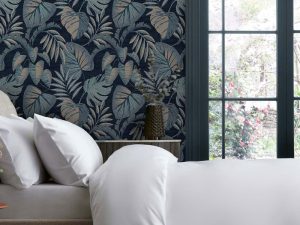 Jungle Leaves Navy Wallpaper features an array of tropical leaves sat upon a deep navy blue backdrop with tones of duck egg, blues and soft orange.