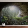 Cave In The Forest Wall Mural is an eye-catching scene that features cool, natural light and space that will make you feel like your room is a cosy hideaway.